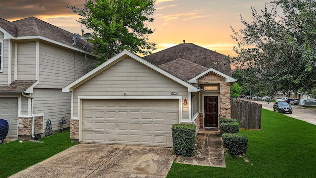 view of front of property featuring a garage, stone siding, a shingled roof, and a front yard