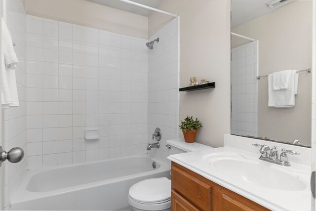 full bathroom featuring vanity, tiled shower / bath combo, and toilet