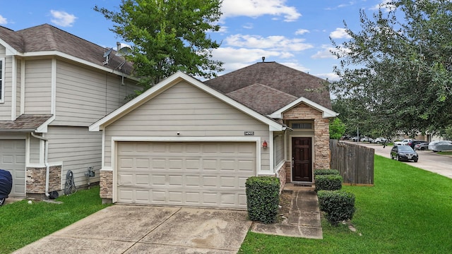 multi unit property featuring concrete driveway, a front lawn, stone siding, an attached garage, and roof with shingles