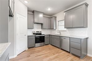 kitchen featuring gray cabinets, dishwashing machine, range with electric cooktop, and light hardwood / wood-style flooring