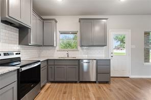 kitchen with gray cabinets, light wood-type flooring, and stainless steel appliances