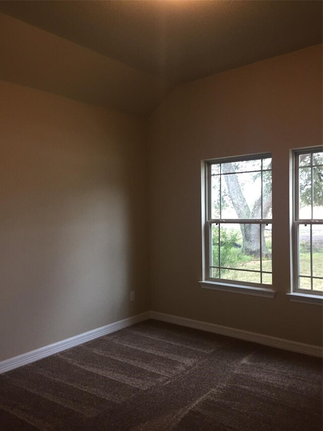 empty room with carpet floors and vaulted ceiling