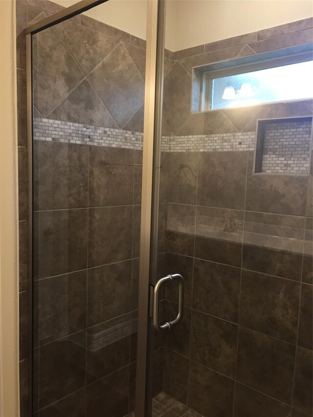 bathroom featuring a shower with door