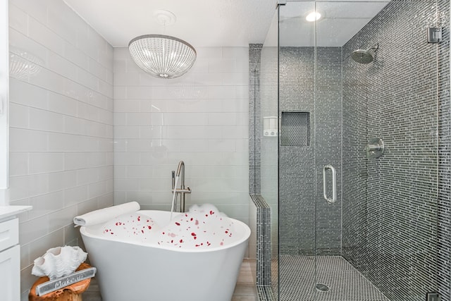 bathroom featuring vanity, tile walls, a textured ceiling, and separate shower and tub