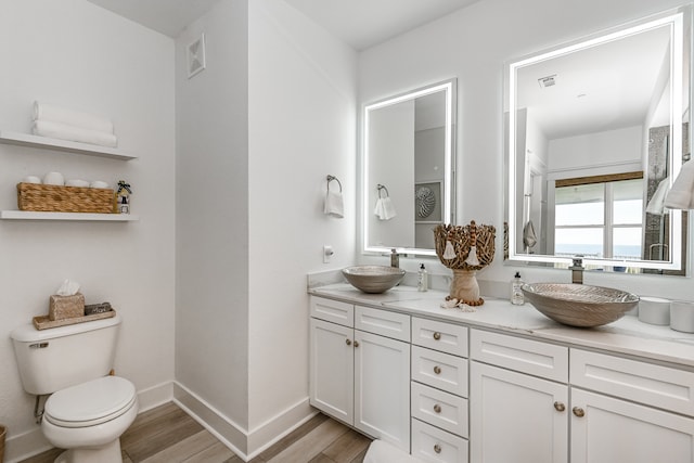 bathroom featuring vanity, toilet, and hardwood / wood-style flooring