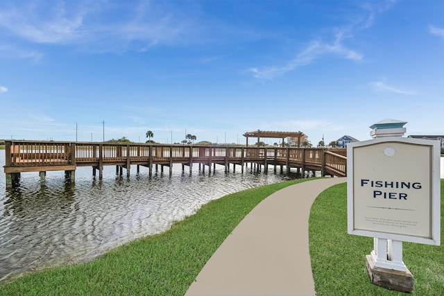 view of dock with a yard and a water view