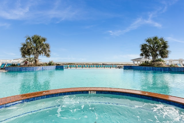 view of pool with a hot tub