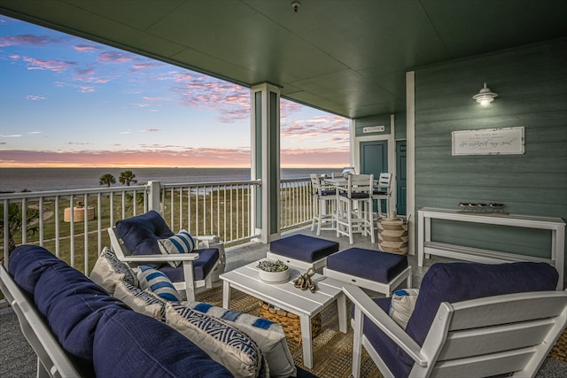 balcony at dusk with a water view and outdoor lounge area