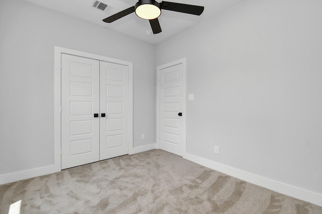 unfurnished bedroom featuring light colored carpet, ceiling fan, and a closet