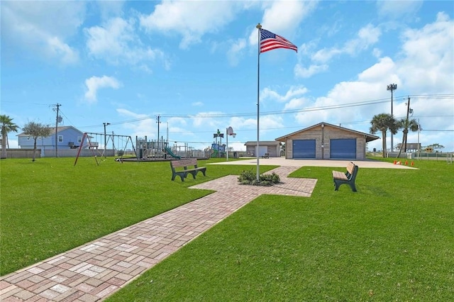 view of property's community featuring a garage, an outbuilding, playground community, and a yard