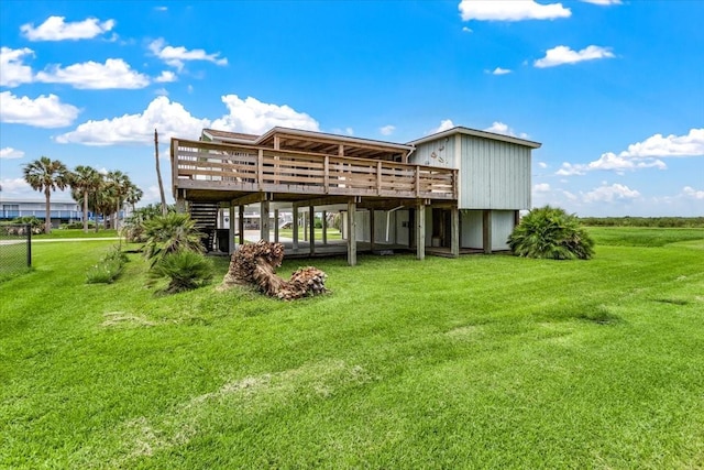 back of house featuring a lawn, a deck, and stairs