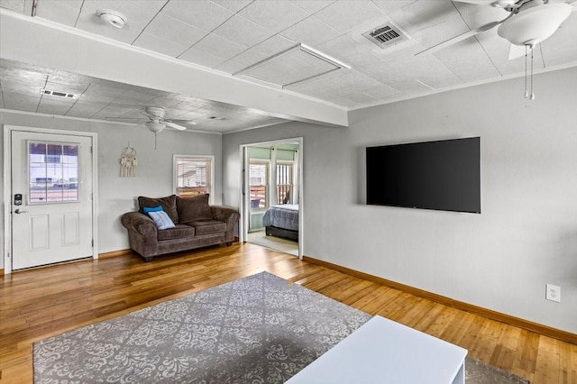 living area with ceiling fan, visible vents, and wood finished floors