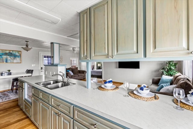 kitchen featuring a wealth of natural light, light countertops, light wood-style floors, open floor plan, and a sink