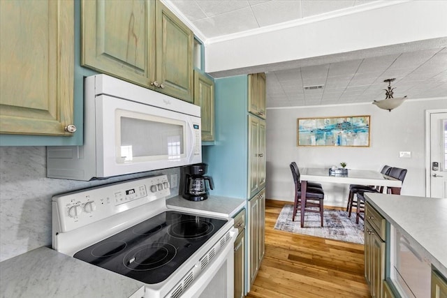 kitchen featuring white appliances, green cabinets, light countertops, ornamental molding, and light wood finished floors