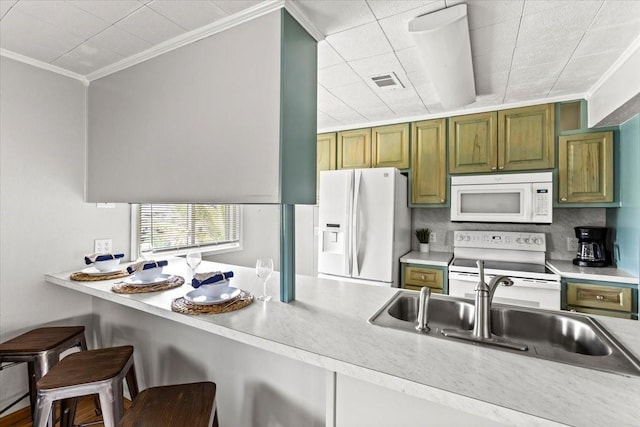 kitchen featuring white appliances, a sink, a breakfast bar, and crown molding