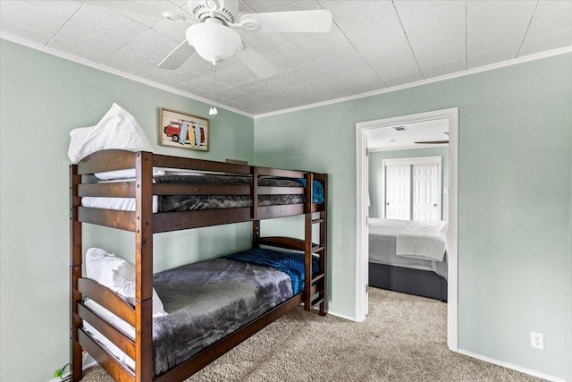 carpeted bedroom featuring ceiling fan, ornamental molding, and baseboards