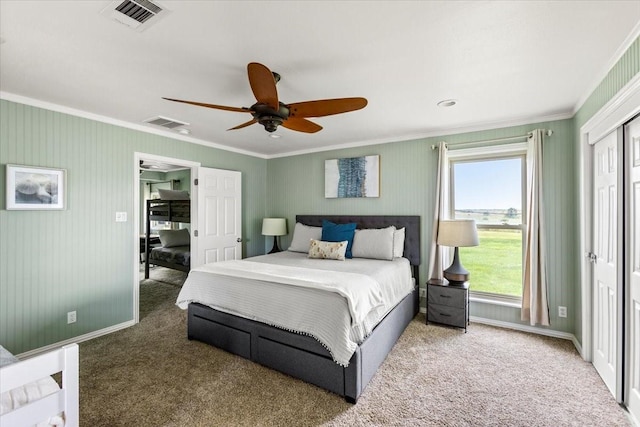 carpeted bedroom with ceiling fan, ornamental molding, visible vents, and baseboards