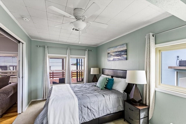 bedroom with ornamental molding, multiple windows, carpet flooring, and a ceiling fan