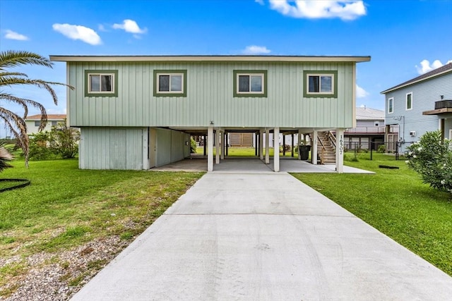 coastal home with stairs, a carport, a front lawn, and driveway