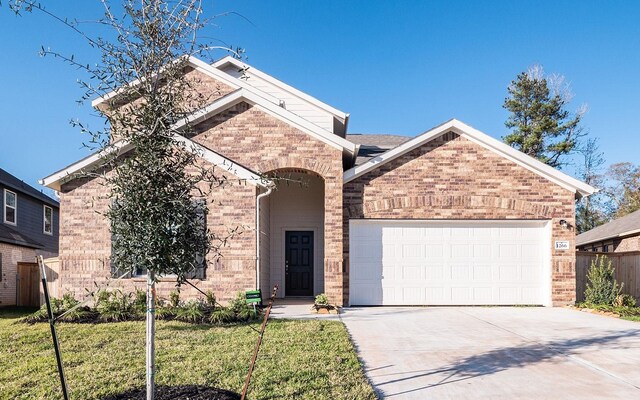 view of front property featuring a garage and a front lawn