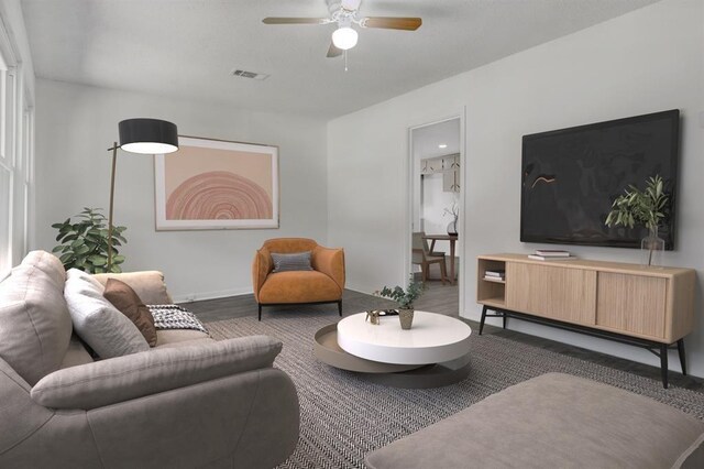 living room featuring dark wood-type flooring and ceiling fan