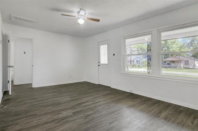 unfurnished room featuring dark hardwood / wood-style flooring, a textured ceiling, and ceiling fan