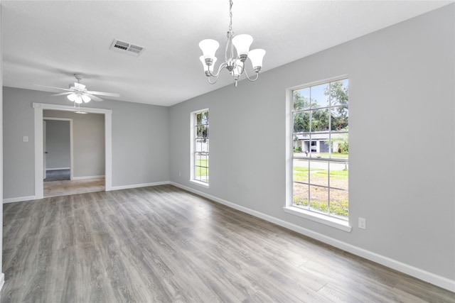 empty room featuring ceiling fan with notable chandelier and wood-type flooring