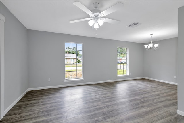 spare room with dark wood-type flooring and ceiling fan with notable chandelier