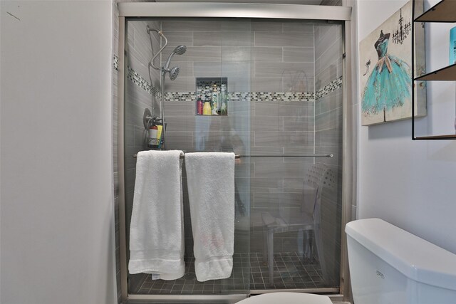 bathroom with toilet and an enclosed shower