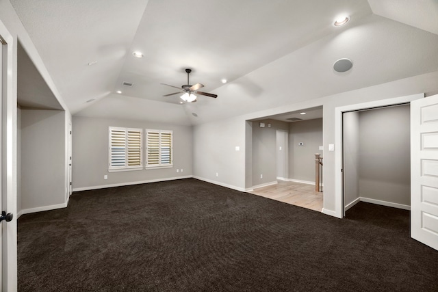 interior space featuring dark colored carpet, lofted ceiling, and ceiling fan