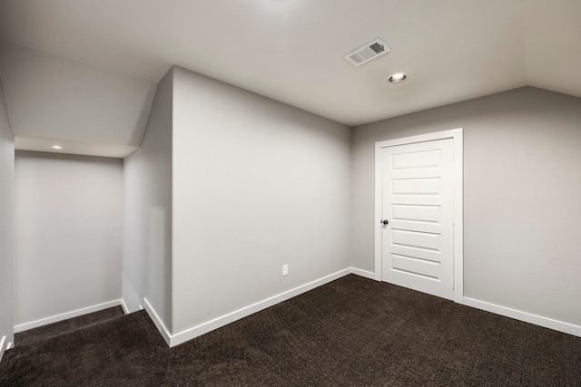 bonus room with lofted ceiling and dark carpet