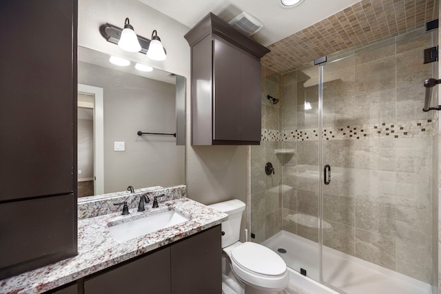 bathroom featuring an enclosed shower, vanity, and toilet