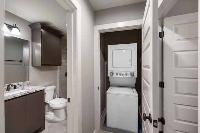 clothes washing area featuring sink and stacked washer / dryer