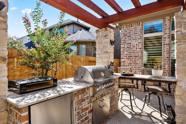 view of patio / terrace with exterior bar, area for grilling, grilling area, and a pergola