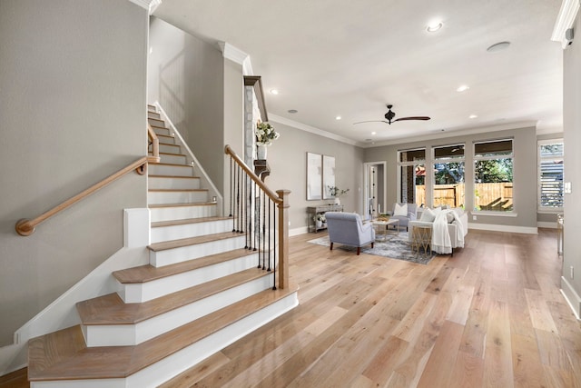 interior space with ornamental molding, wood-type flooring, and ceiling fan