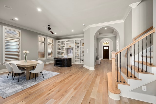 dining area with crown molding, ceiling fan with notable chandelier, and light hardwood / wood-style flooring