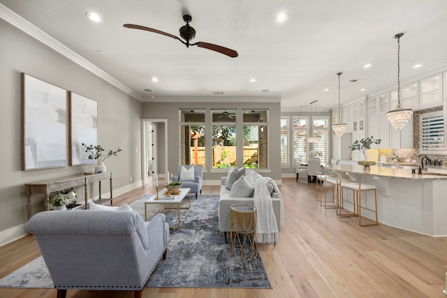 living room featuring crown molding, ceiling fan, and light wood-type flooring