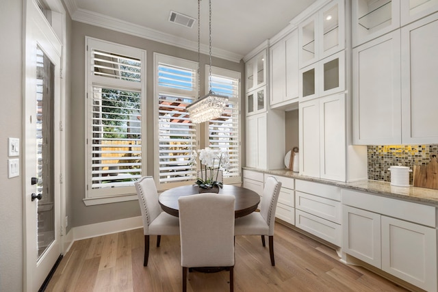 dining area featuring crown molding and light hardwood / wood-style floors