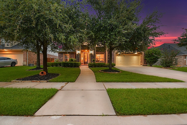 view of front of property with a garage and a lawn