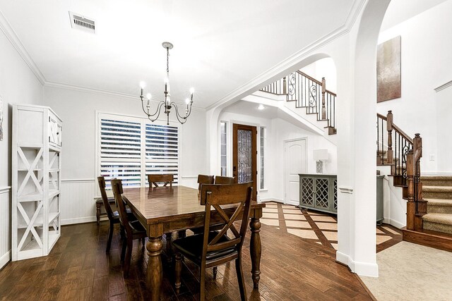 dining area featuring an inviting chandelier, wood-type flooring, and ornamental molding