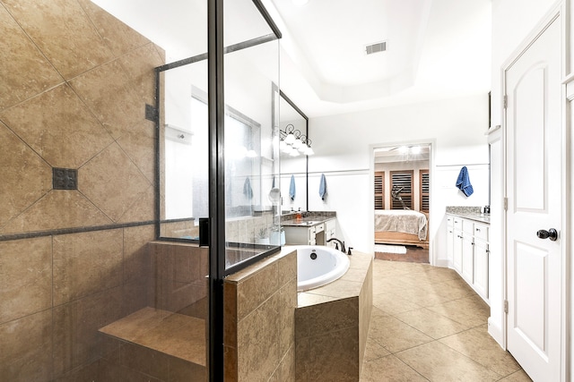 bathroom featuring vanity, tile patterned floors, shower with separate bathtub, and a tray ceiling