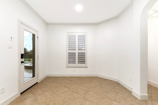 empty room featuring light tile patterned floors and crown molding