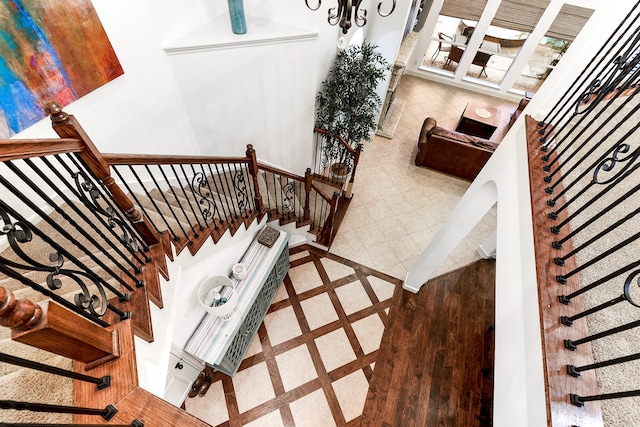 staircase with a high ceiling and hardwood / wood-style floors