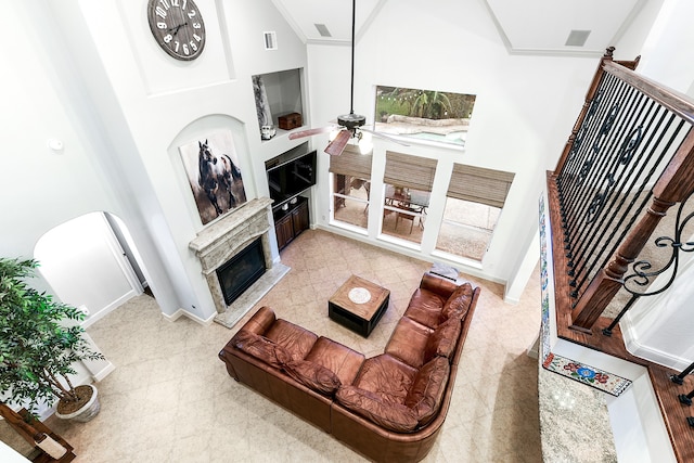 tiled living room with a high ceiling, crown molding, and ceiling fan