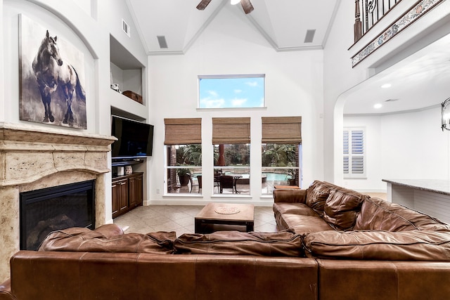 living room with high vaulted ceiling, a premium fireplace, ceiling fan, and light tile patterned floors