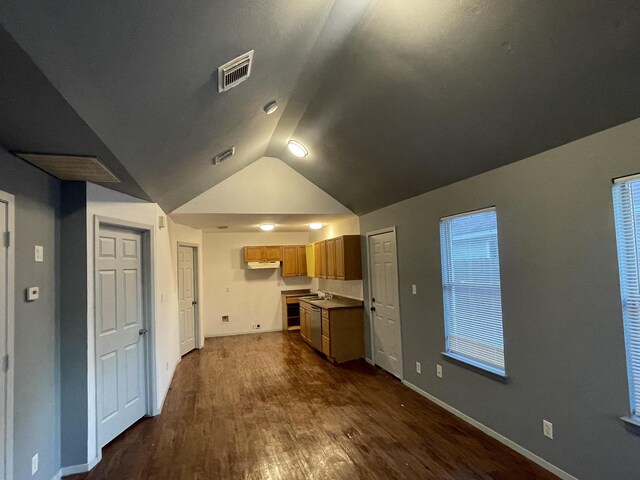 unfurnished living room with vaulted ceiling and dark wood-type flooring