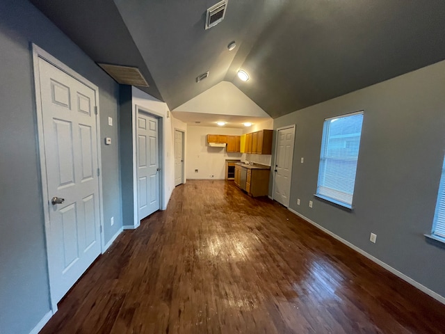 unfurnished living room featuring dark hardwood / wood-style floors and lofted ceiling