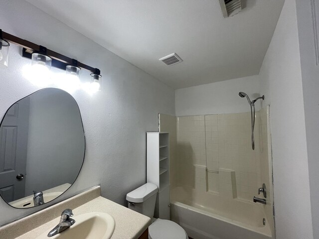 full bathroom with vanity, tiled shower / bath combo, and toilet