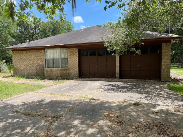 1055 County Road 452, Sweeny, TX 77480 - single story home with concrete driveway, an attached garage, brick siding, and a shingled roof