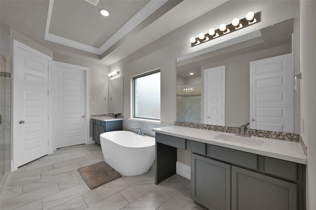 bathroom with double vanity, a tray ceiling, tile patterned floors, and a tub